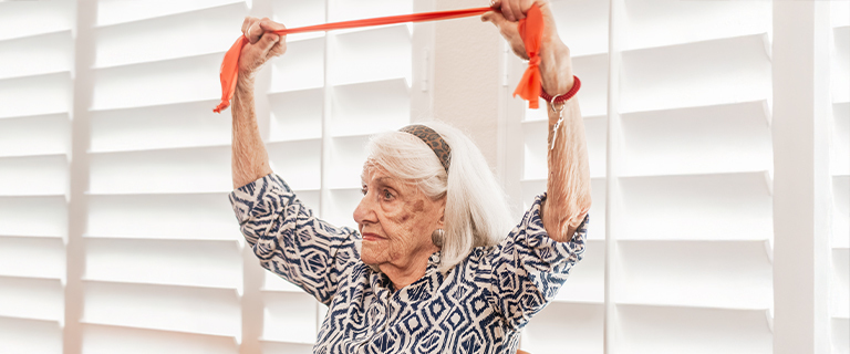 Senior woman exercising with resistance band indoors