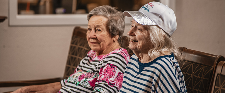 Two elderly women sitting in a common area