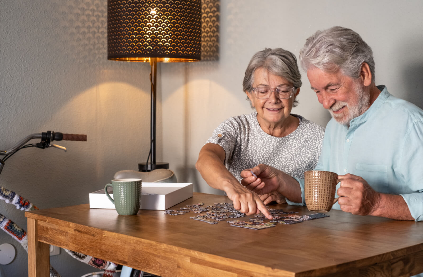 Two seniors enjoying a puzzle together at a table.
