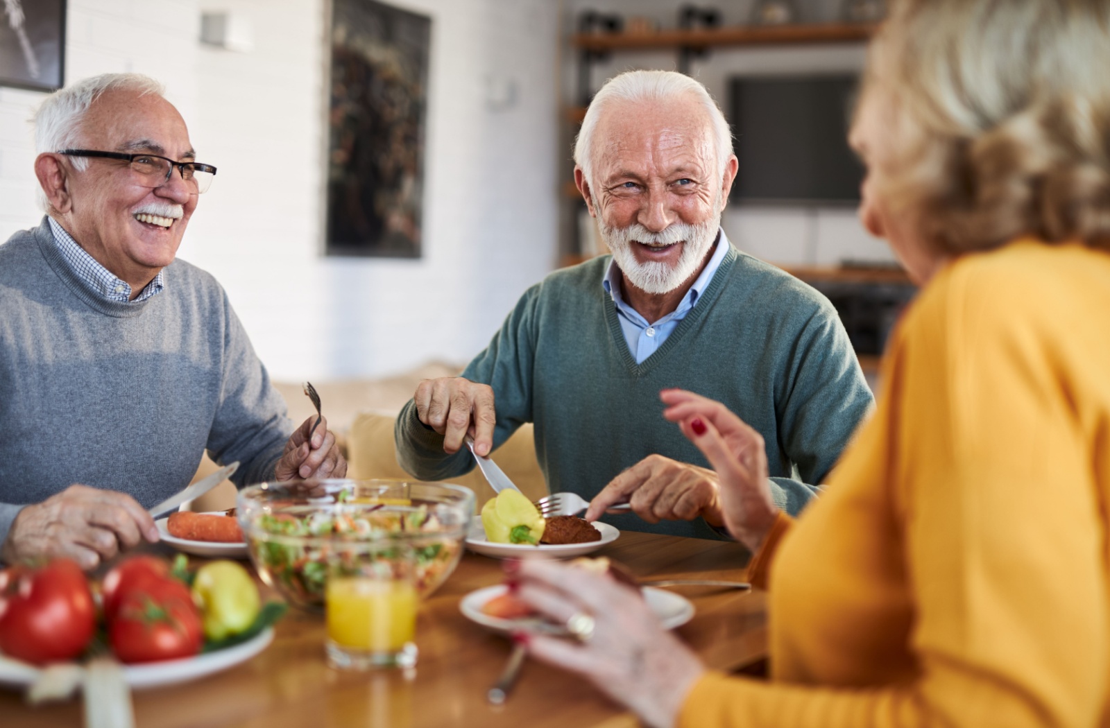 Three seniors enjoying a meal and conversation