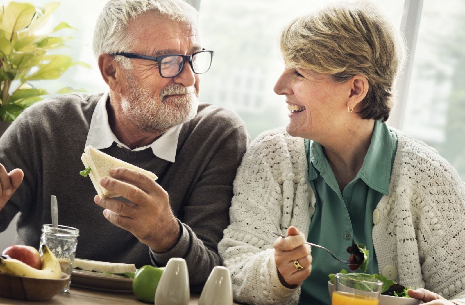 Two seniors enjoying a meal together, smiling.