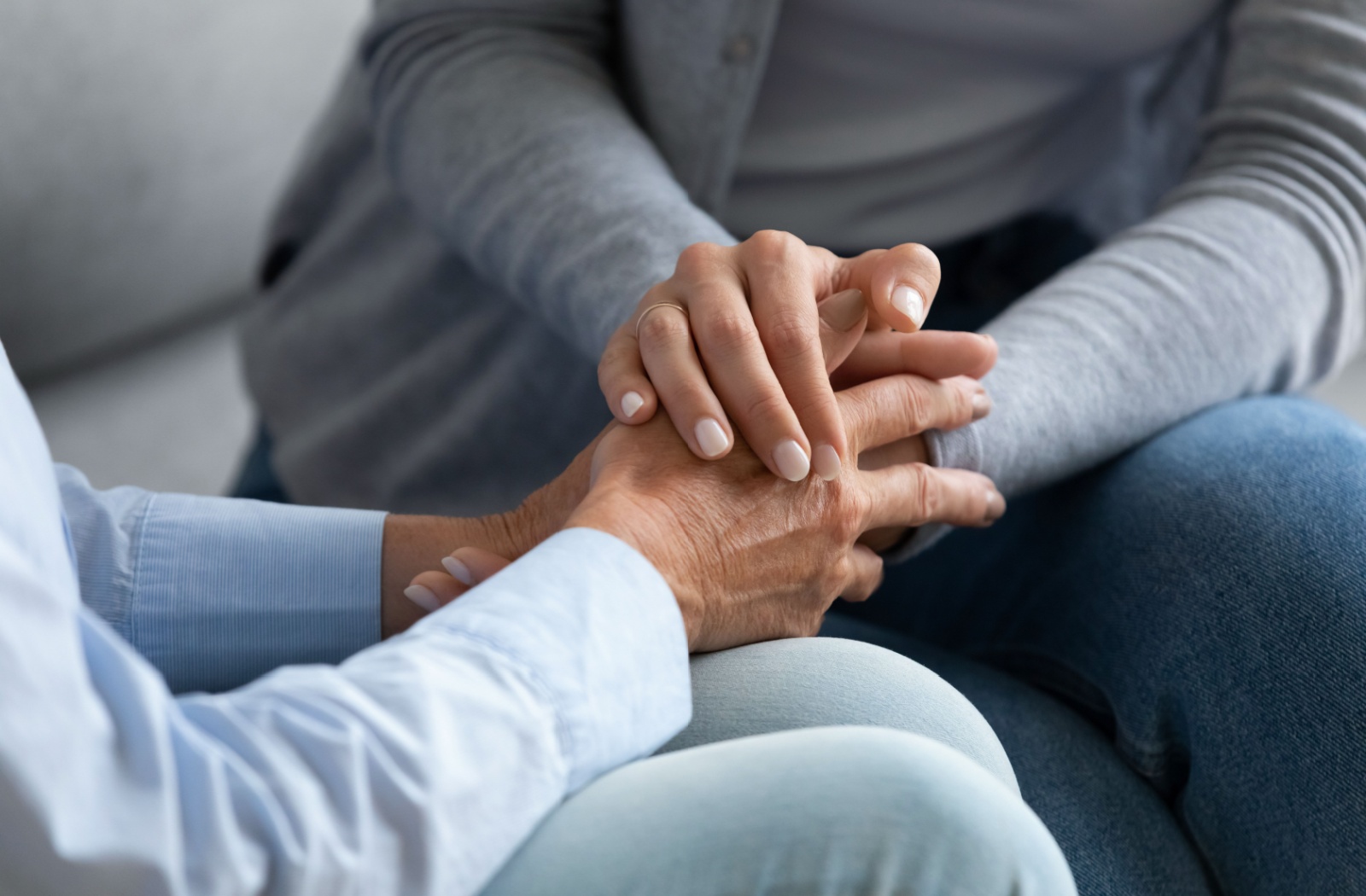 Hands of two people holding each other