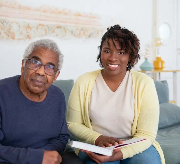 Elderly man and caregiver smiling together.