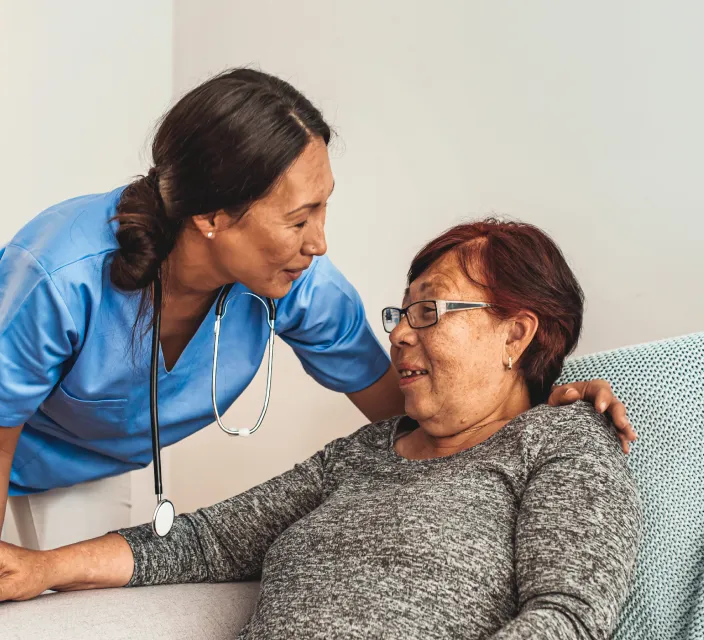 A caregiver interacts warmly with a resident.