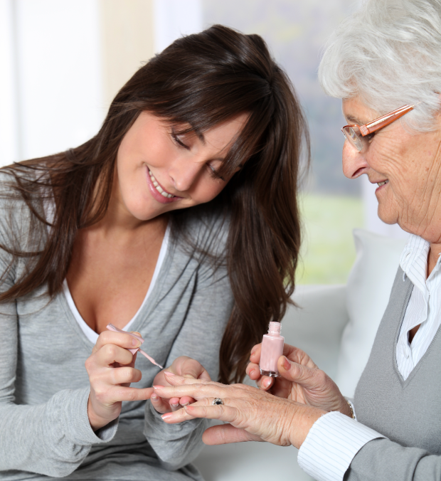 A caregiver applying nail polish to a resident's nails.