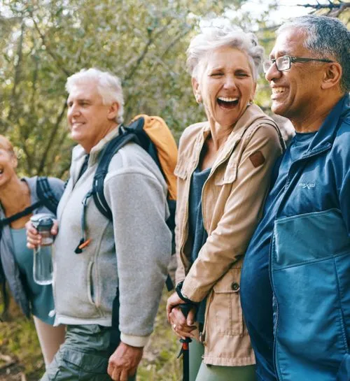 Seniors hiking and enjoying a joyful moment outdoors.