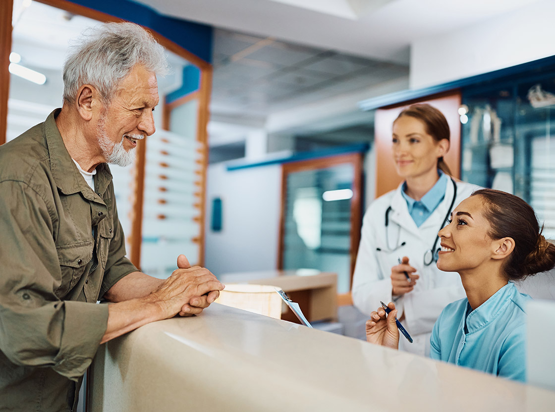 Staff interacting with a resident at reception.