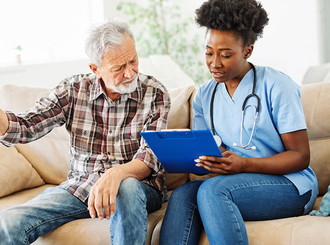 Health professional assisting an elderly man.