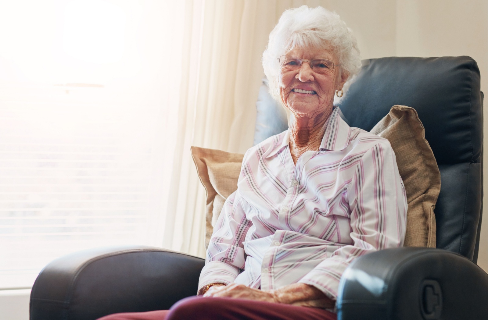 Smiling elderly woman in a cozy chair