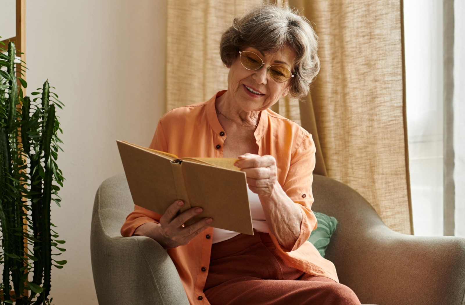 Senior woman reading a book in a cozy chair