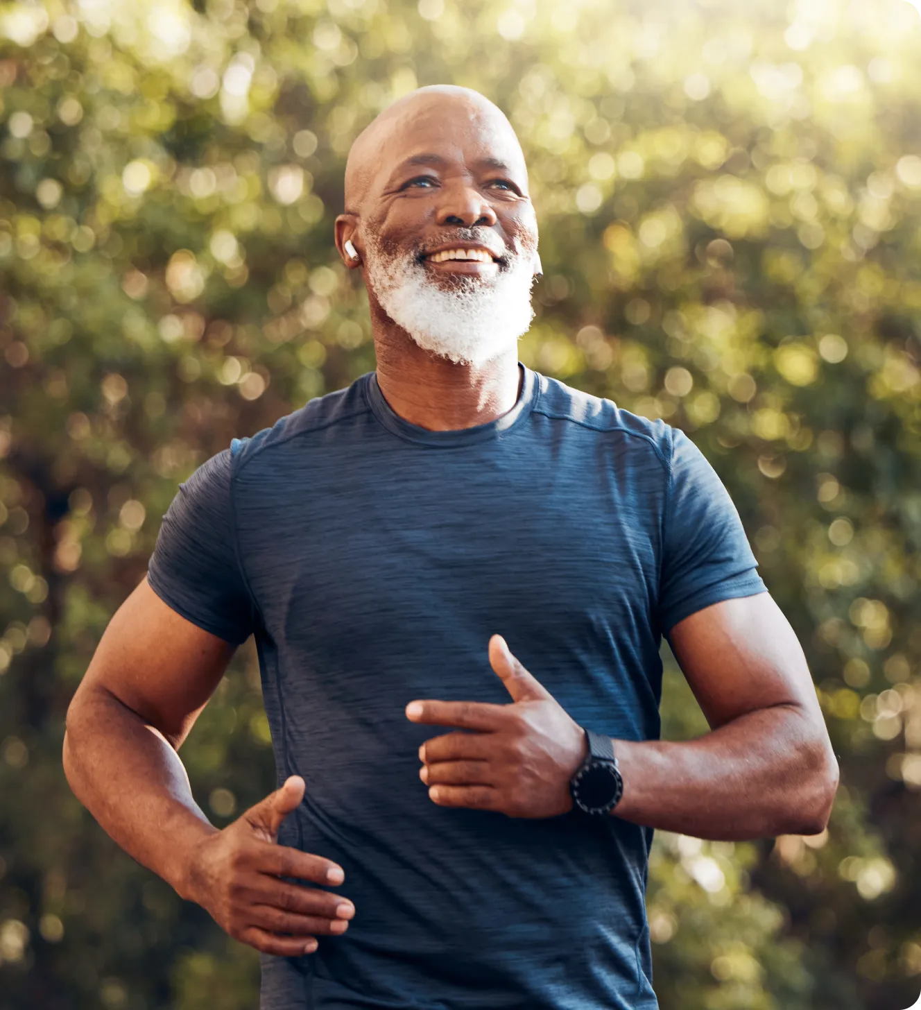 Older man jogging outdoors with a big smile.