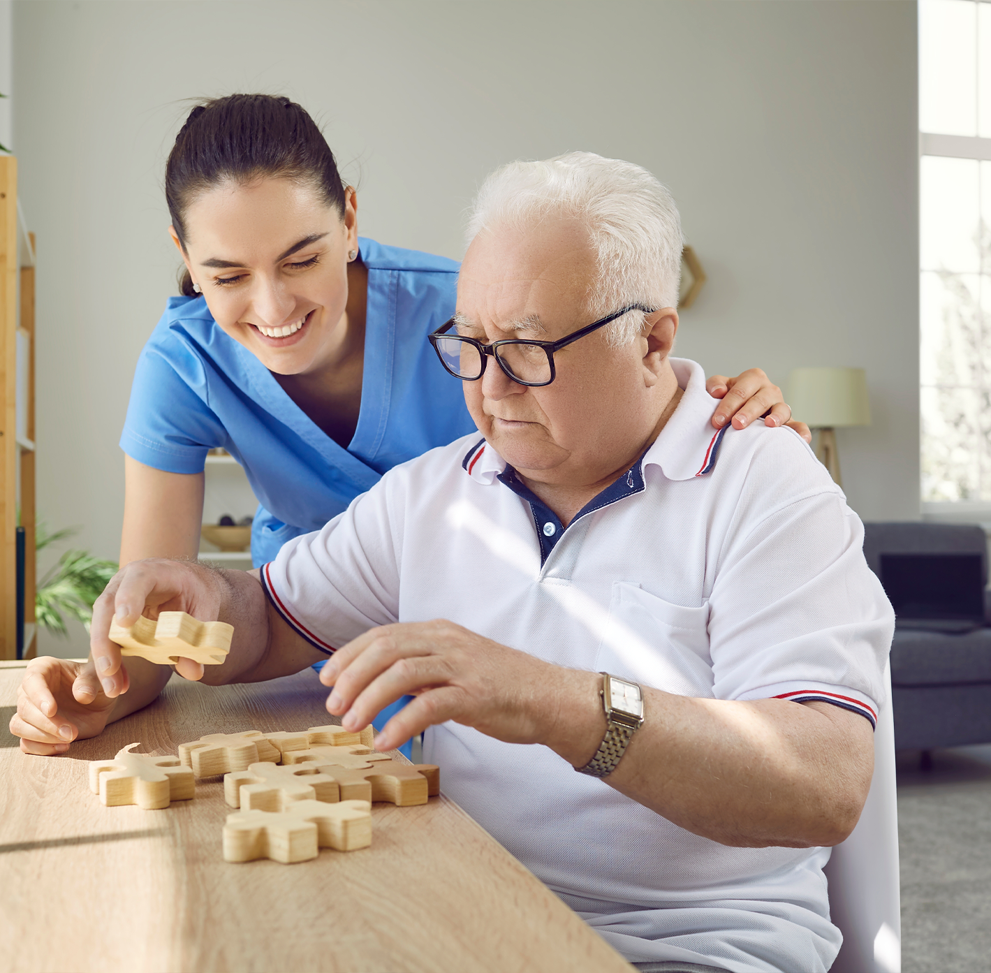 Senior man engaging in an activity with a staff member