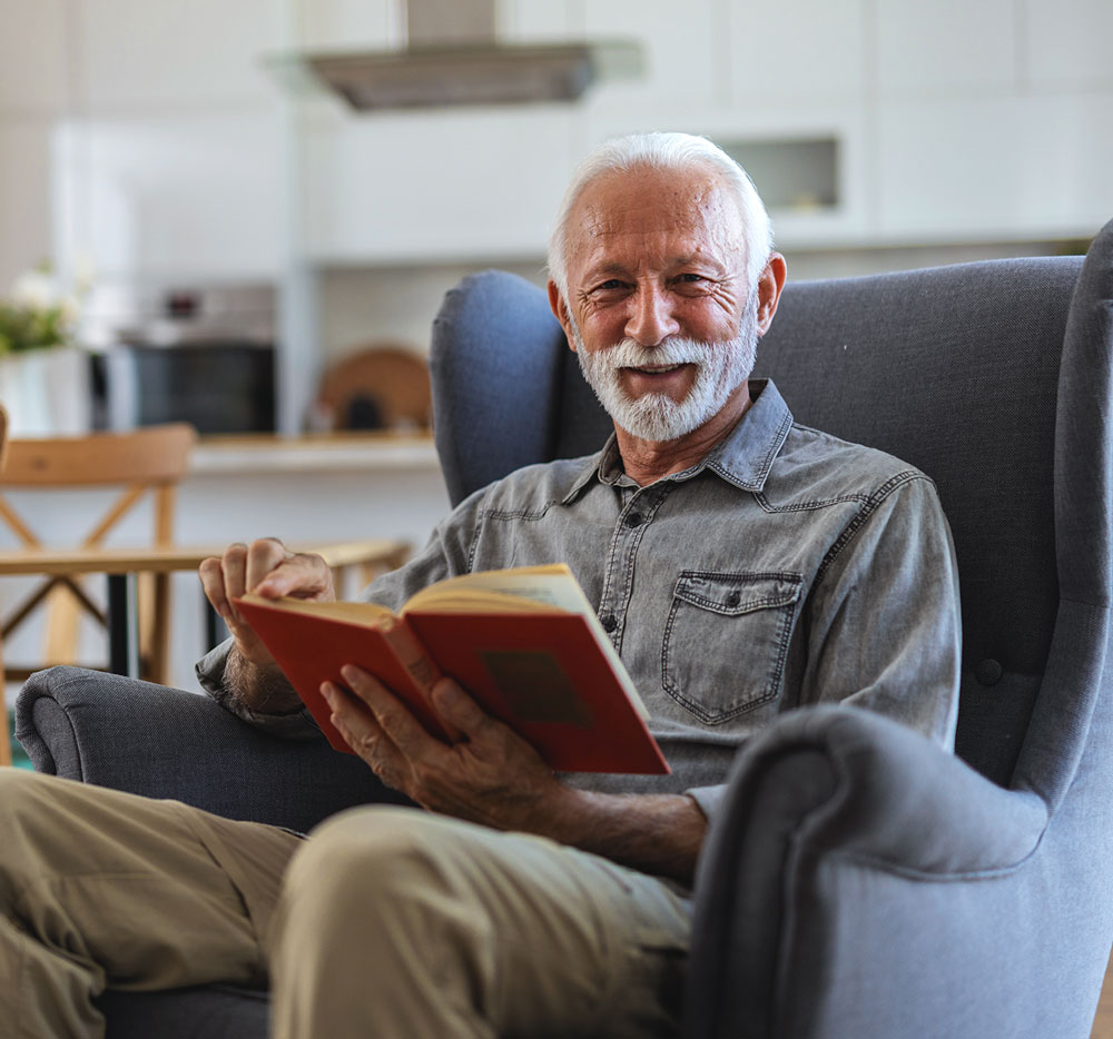 Senior man enjoying a book in a cozy chair