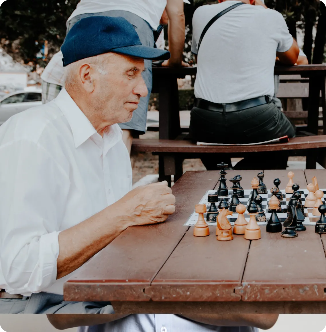 Seniors playing chess in an outdoor setting.