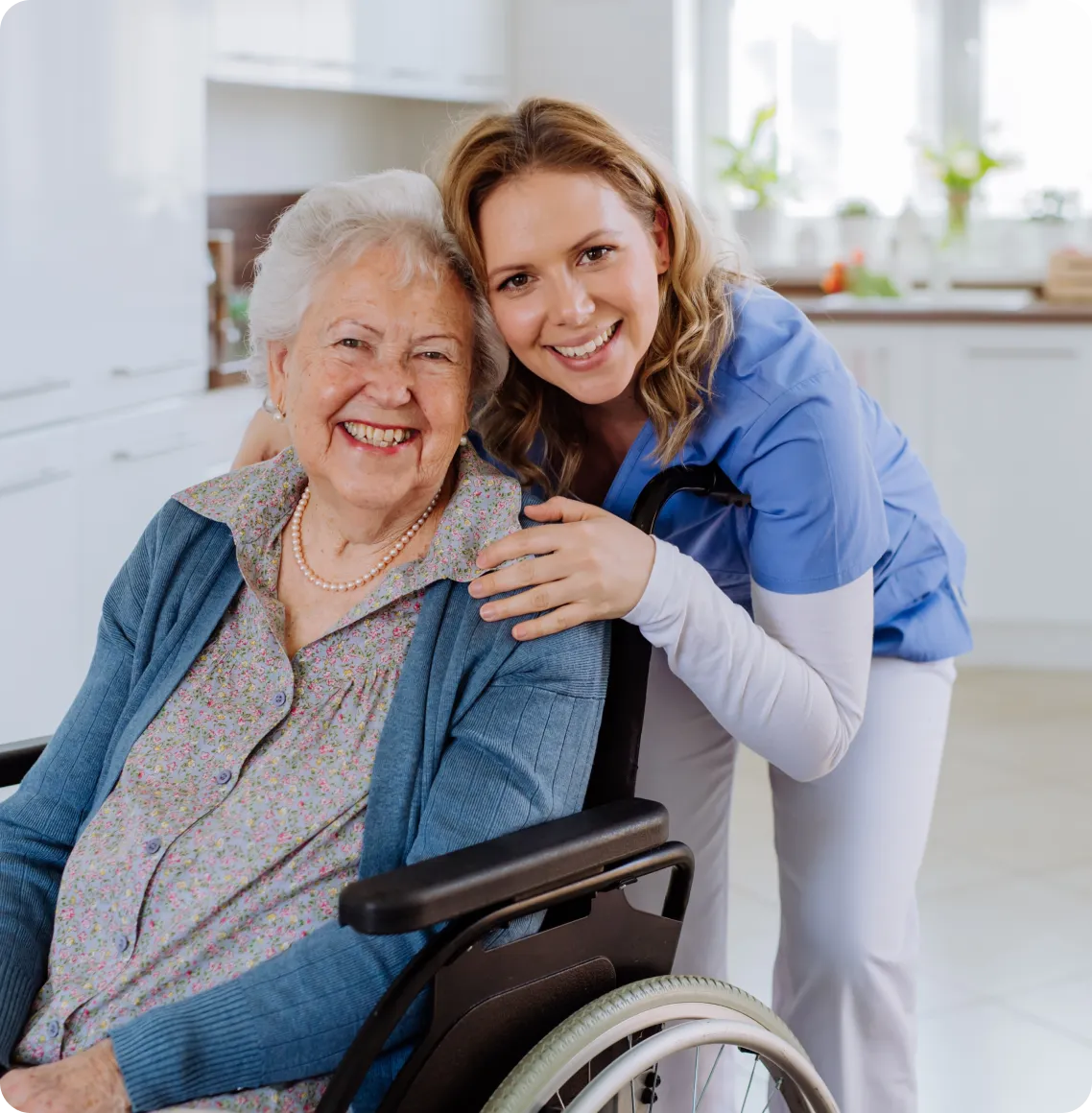 Staff member smiling with a resident in a kitchen