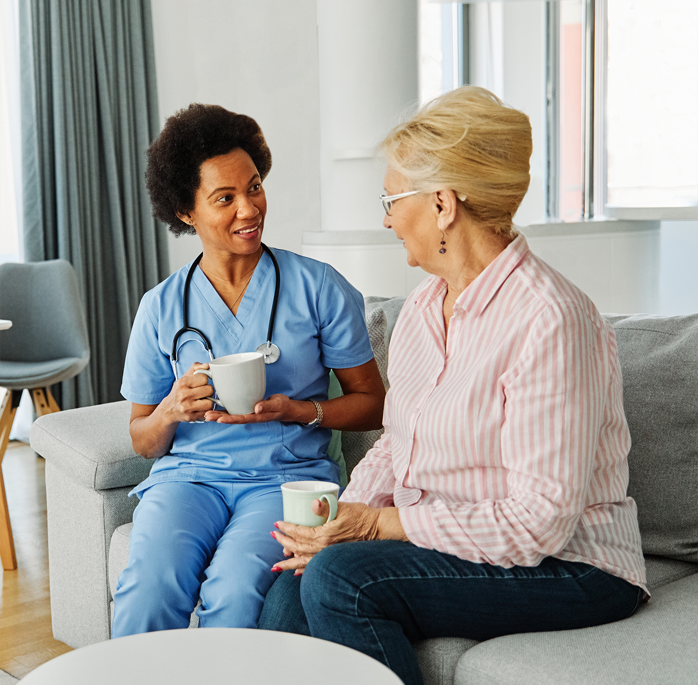 Staff member chatting with a resident over tea.
