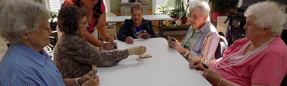 Seniors playing cards together in a common area.