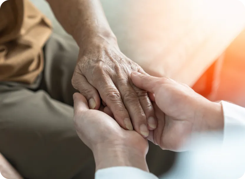 Caregiver holding a senior's hand