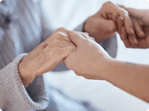 Hands of residents and staff holding each other