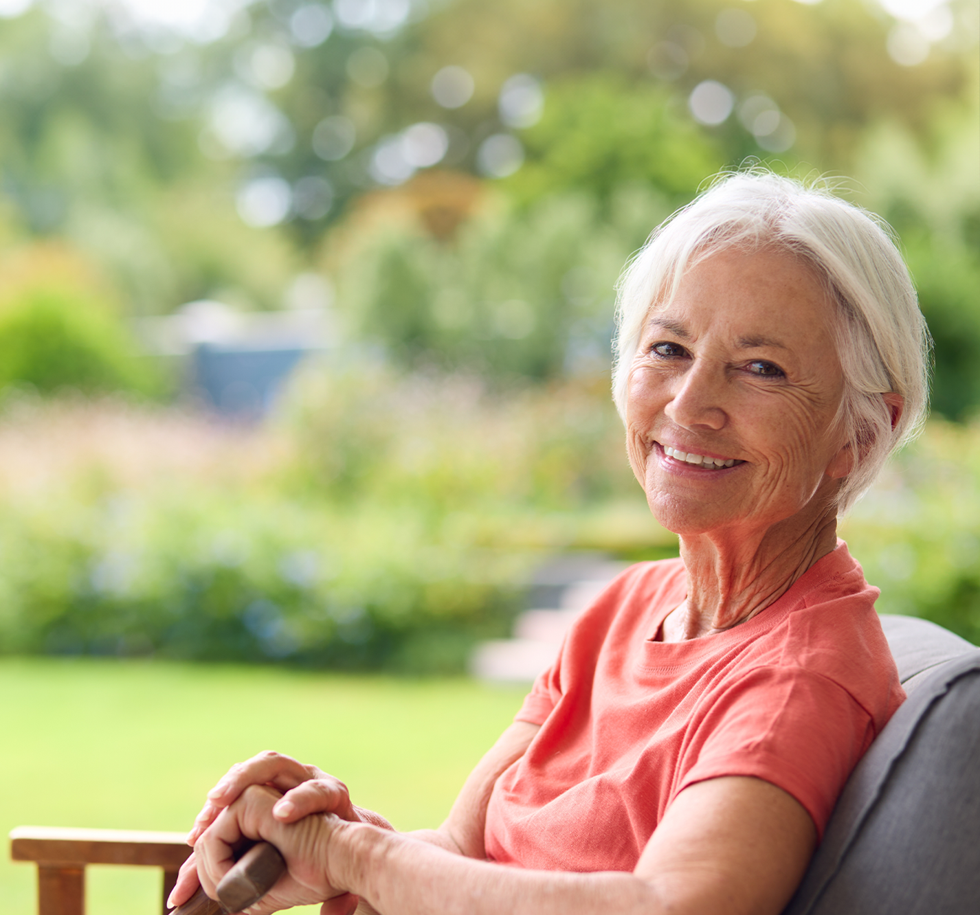 Smiling senior woman sitting in a garden.