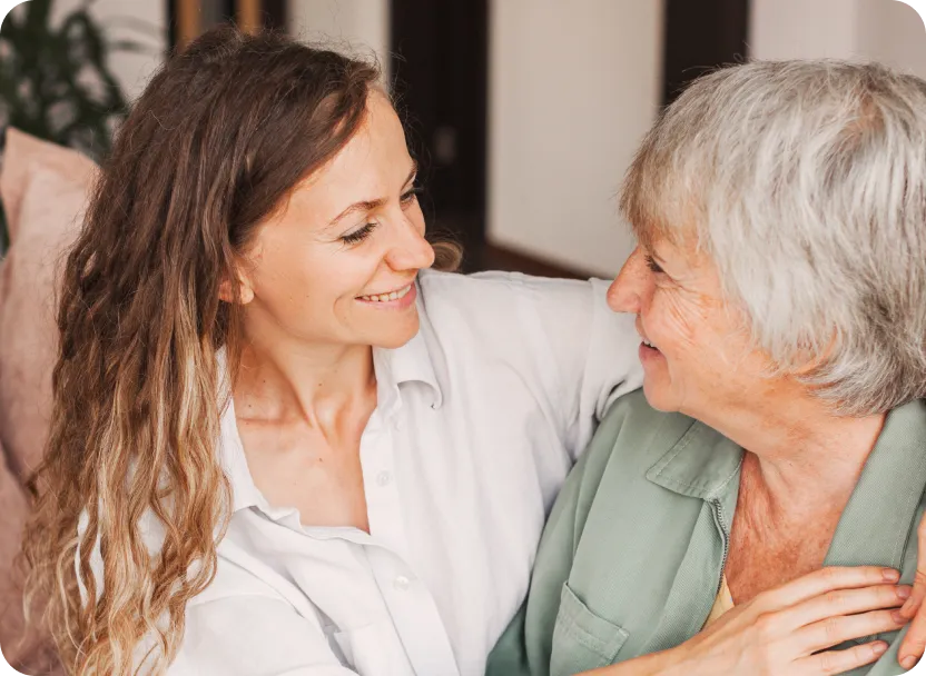 Caregiver smiling and interacting with a senior resident.