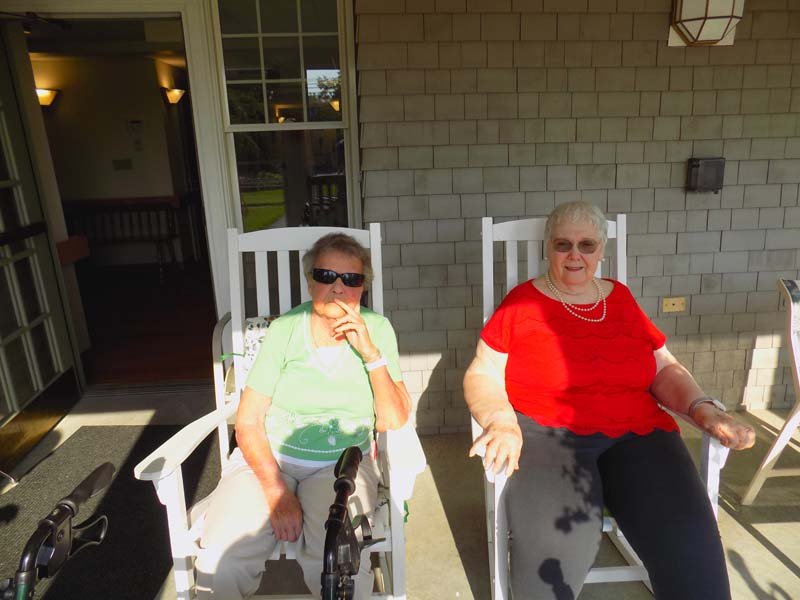 Two residents enjoying the outdoors on a porch.