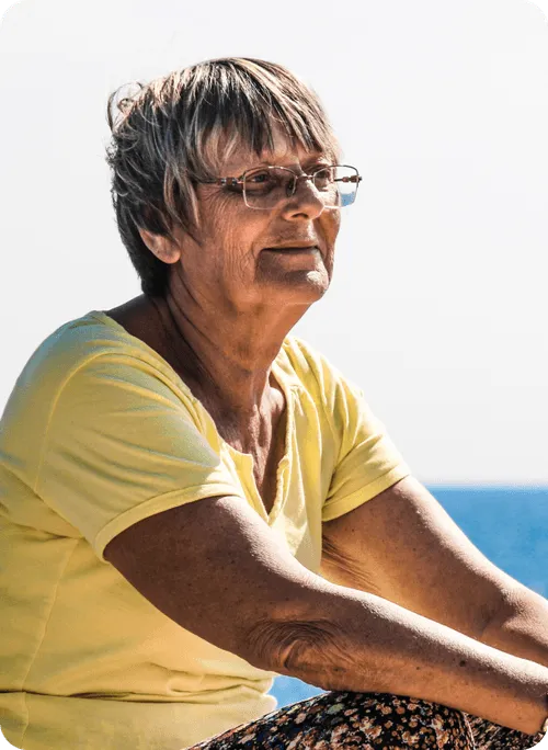 Senior woman with glasses smiling outdoors
