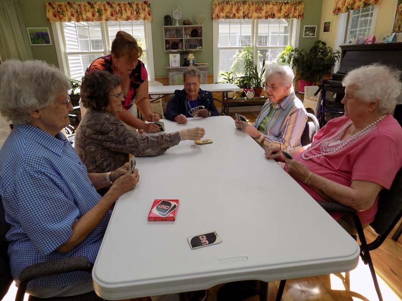 Residents playing a card game in a communal area.
