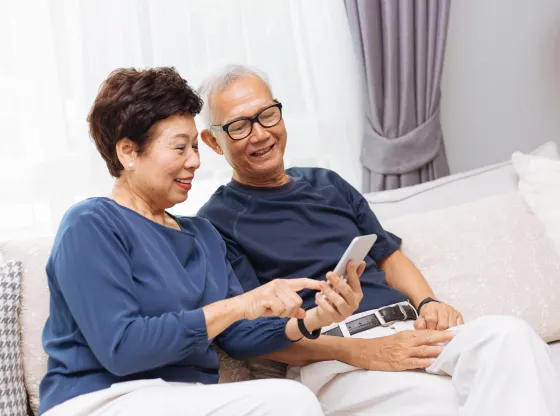 Two seniors happily engaging with a smartphone.