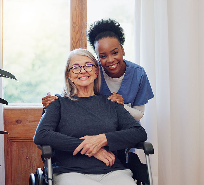 Smiling resident with caregiver in a bright interior space