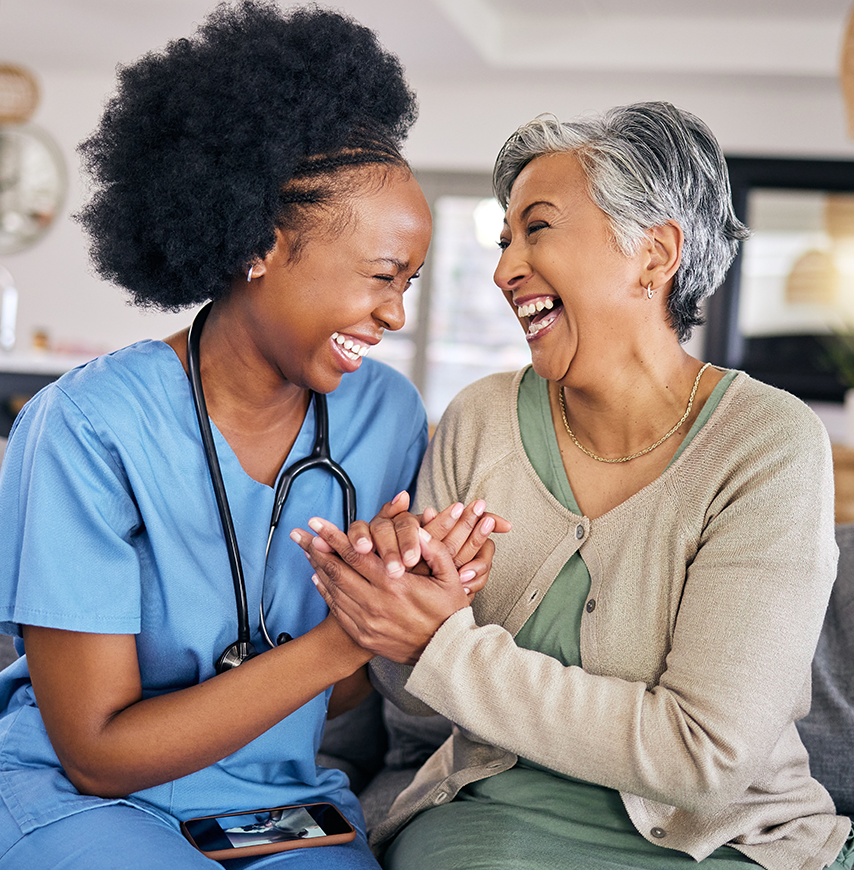 A caregiver and a resident sharing a joyful moment.