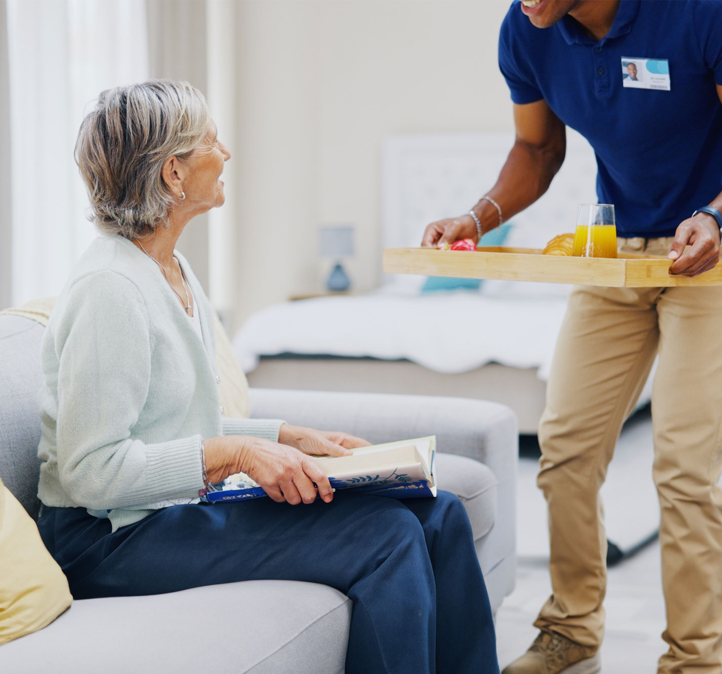 Staff serving food to a resident in a comfortable setting.
