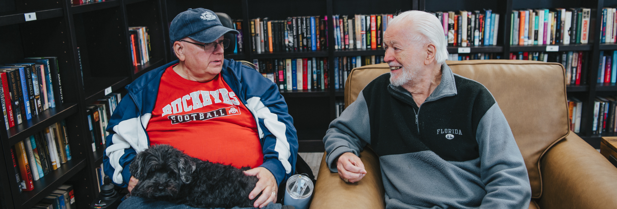 Two residents enjoying a conversation in a library.