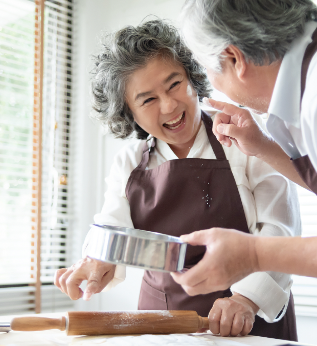 Two seniors baking together in a kitchen.