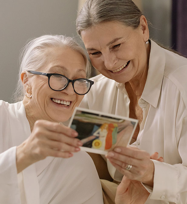 Two women looking at a photo together.