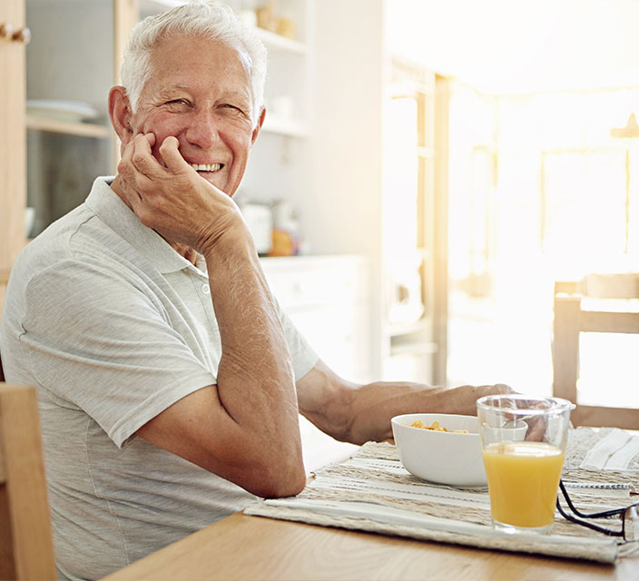 Smiling senior man enjoying a bowl of food.