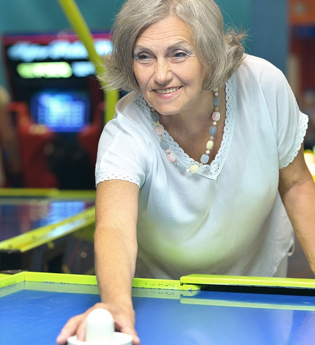 Senior woman enjoying a game of air hockey.