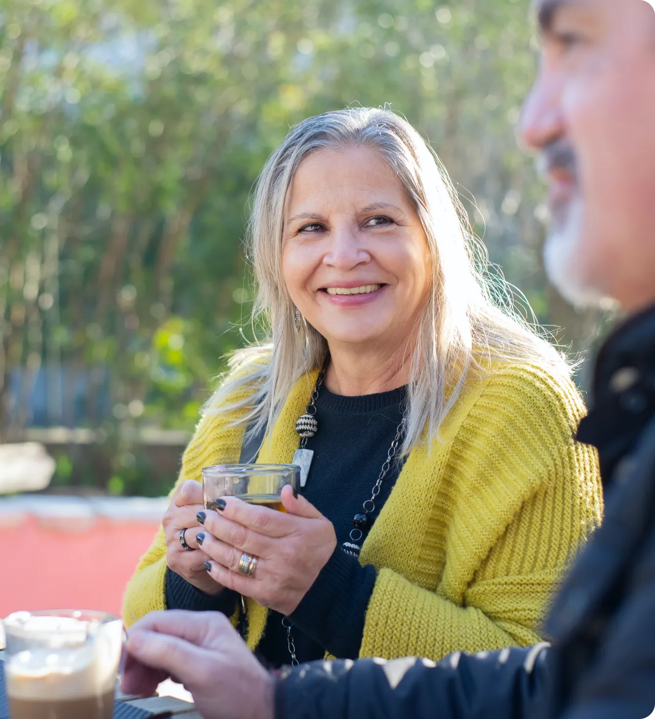 Senior woman smiling while holding a glass.