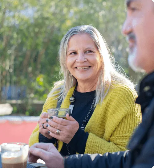 Resident enjoying a cup in an outdoor setting.