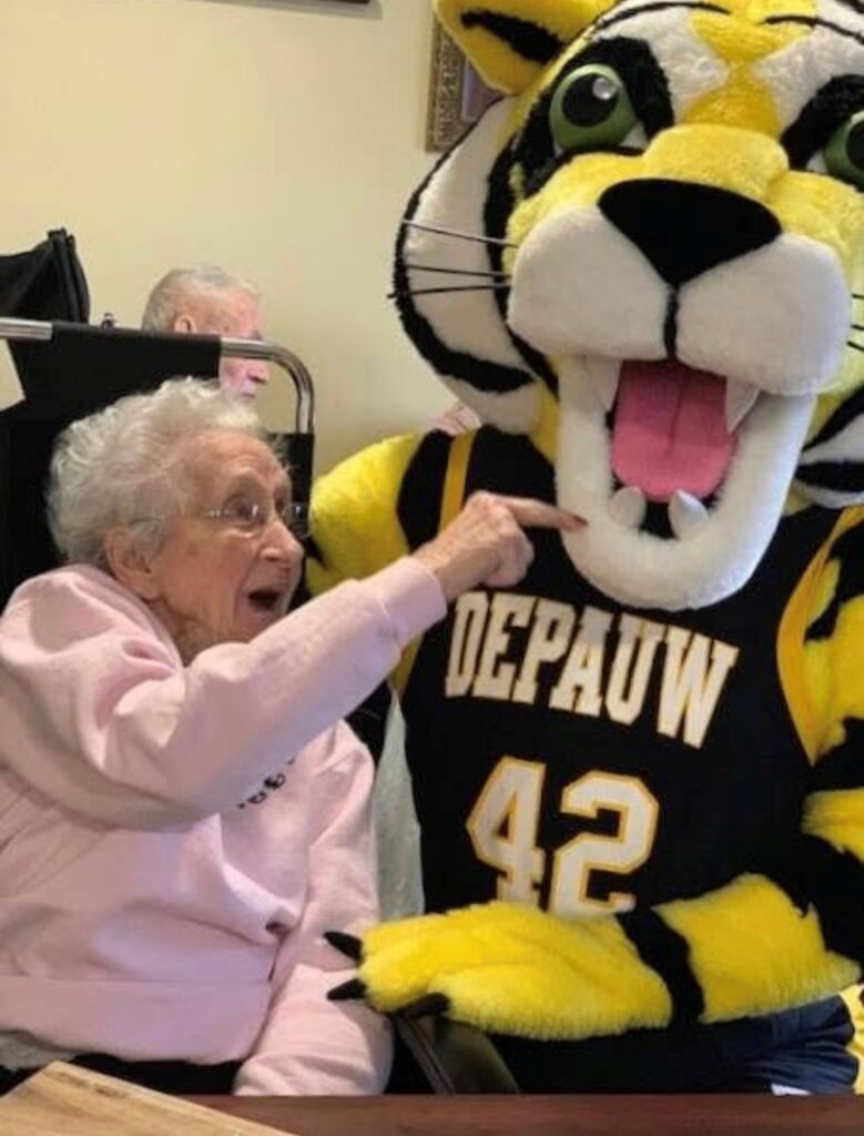Elderly resident interacting with mascot