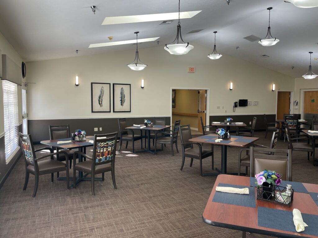 Dining area with tables and floral centerpieces.