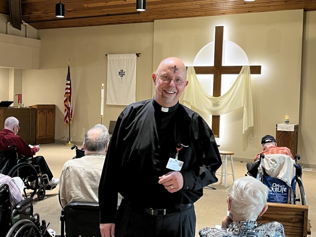 Clergy member leading a gathering in a common area.