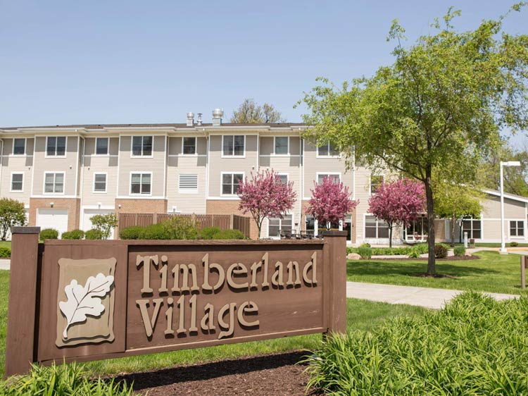 Exterior view of Timberland Village with landscaping.