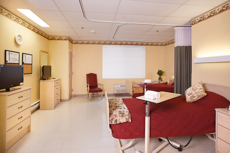 A shared resident room with two beds and furnishings.