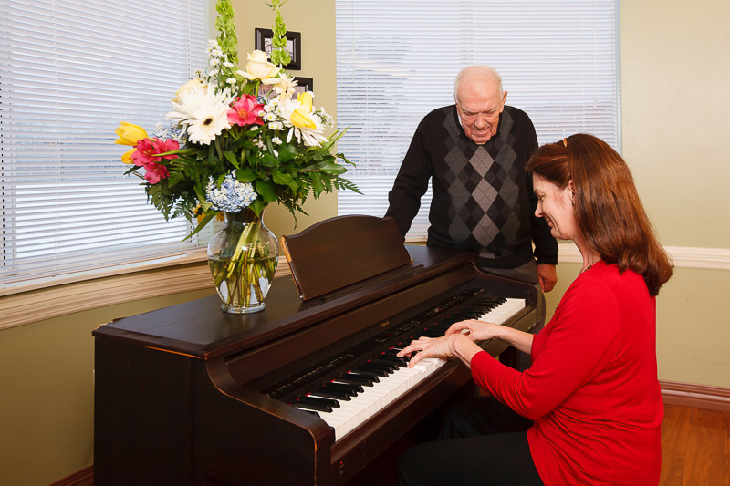 Residents enjoying a musical activity at a piano.