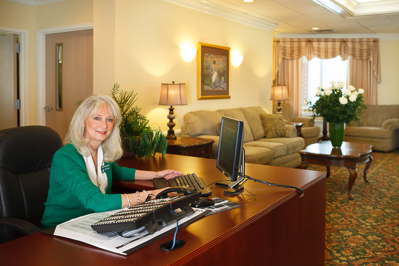 Female receptionist in a welcoming lobby area.