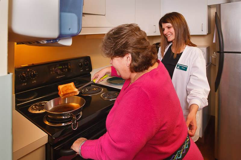 Staff assisting a resident in cooking