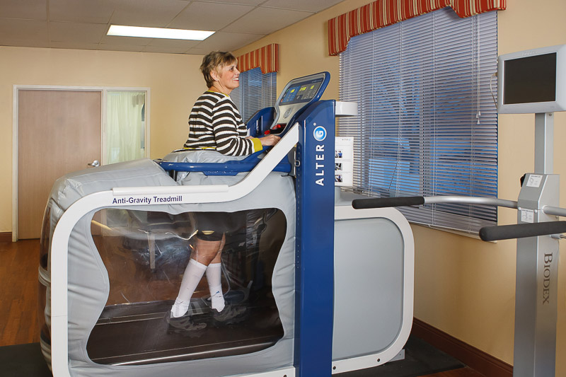 Resident using an anti-gravity treadmill indoors.