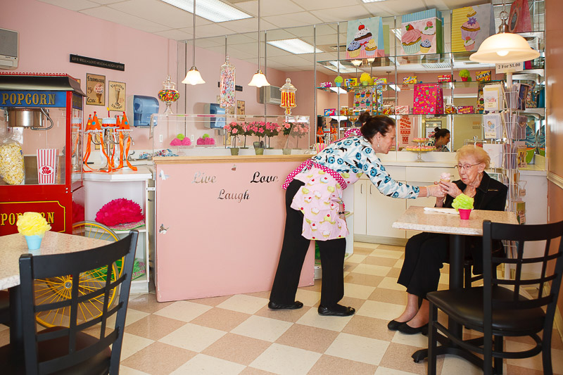 Staff serving ice cream to a resident in a café setting.