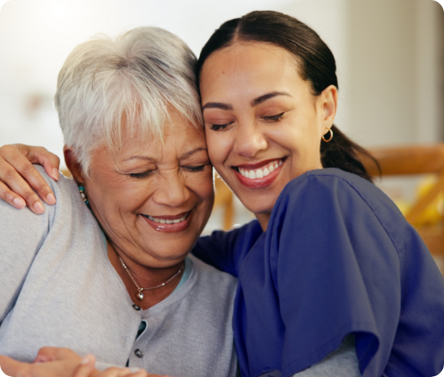 Smiling woman embracing a caregiver.